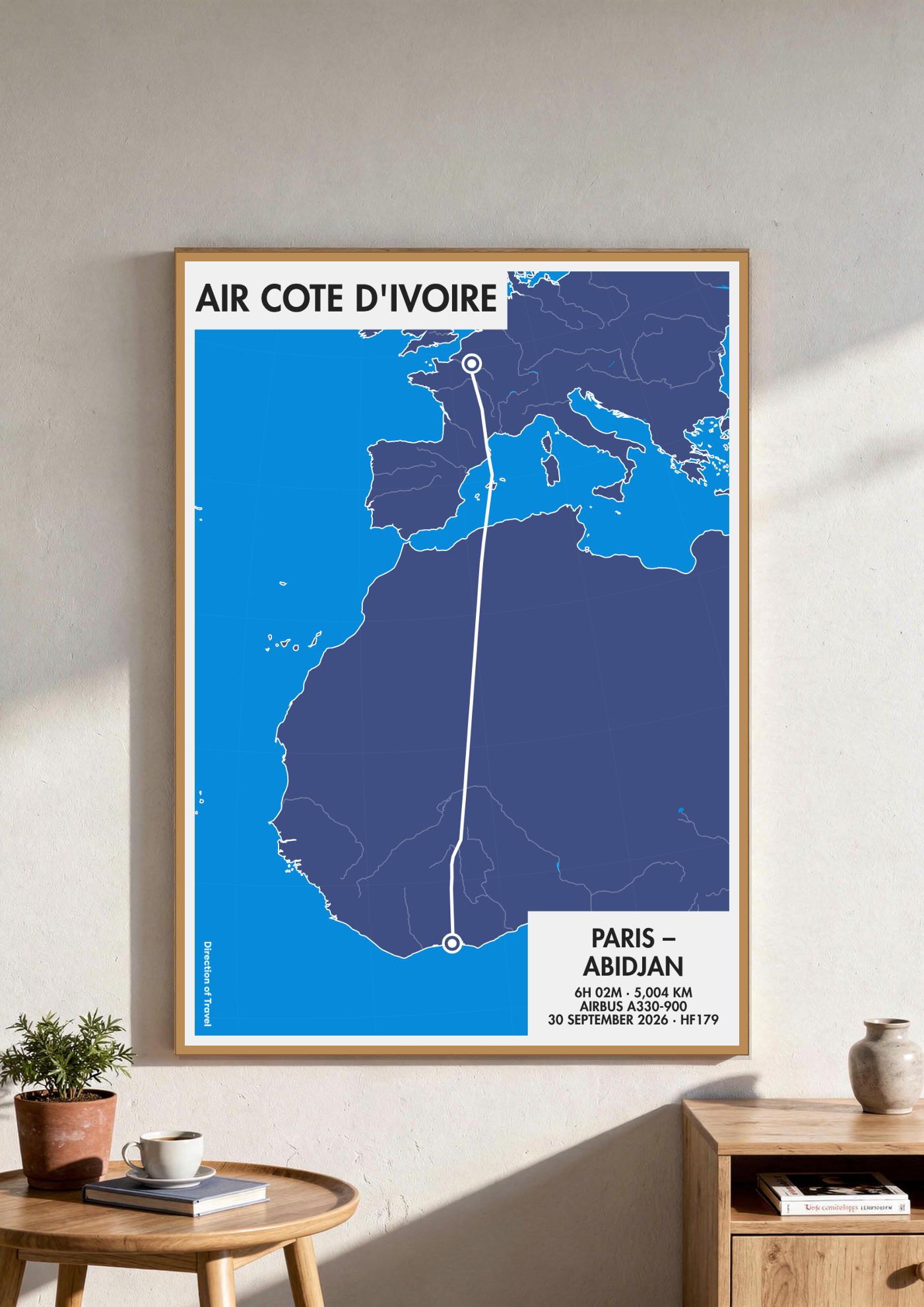 Paris to Abidjan A2 poster in a wooden frame in a room (AI-generated)